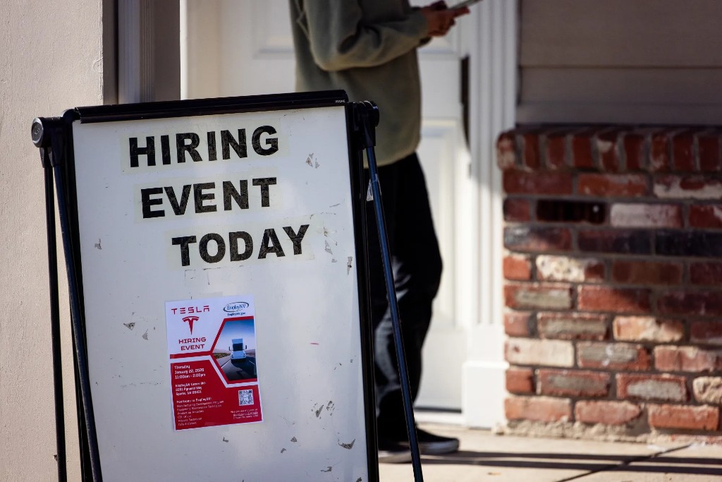 Outdoor hiring event sign on a sidewalk in front of a building, with hiring event flyer attached